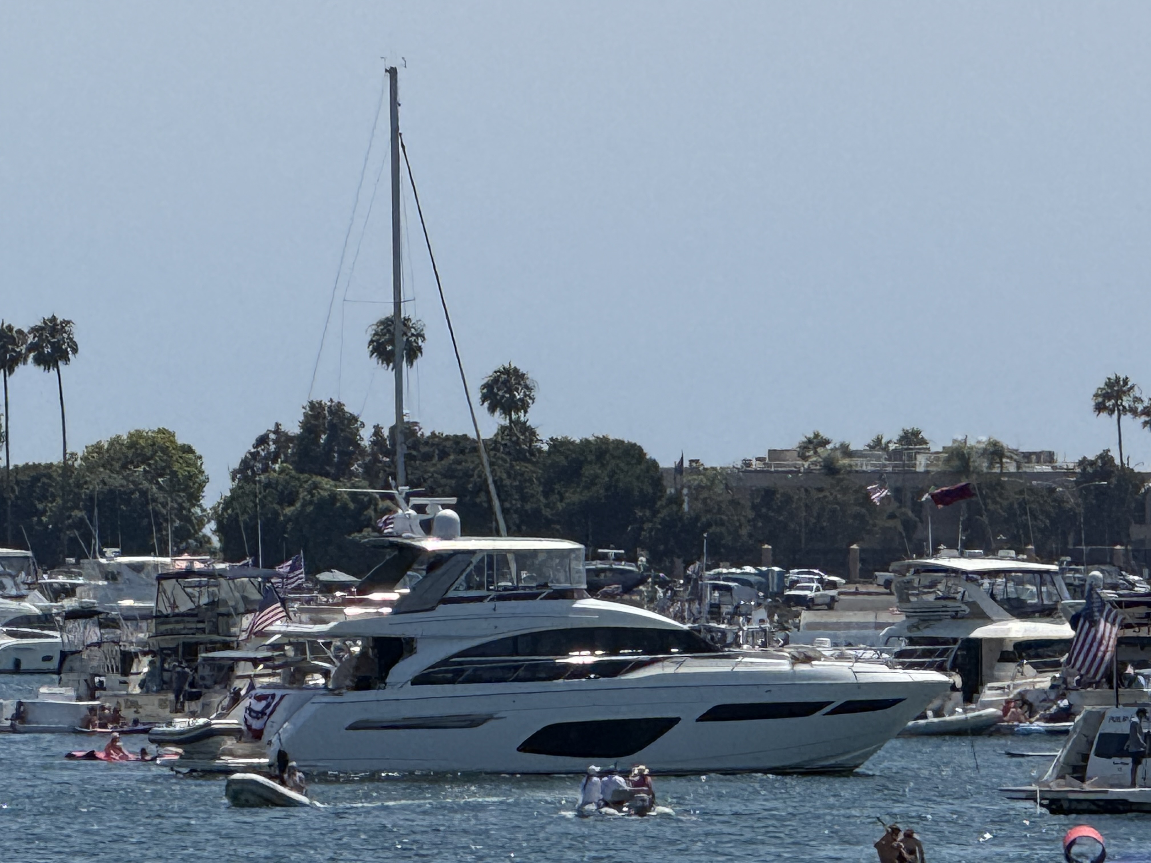 Motor yacht cruising in harbor with palm trees